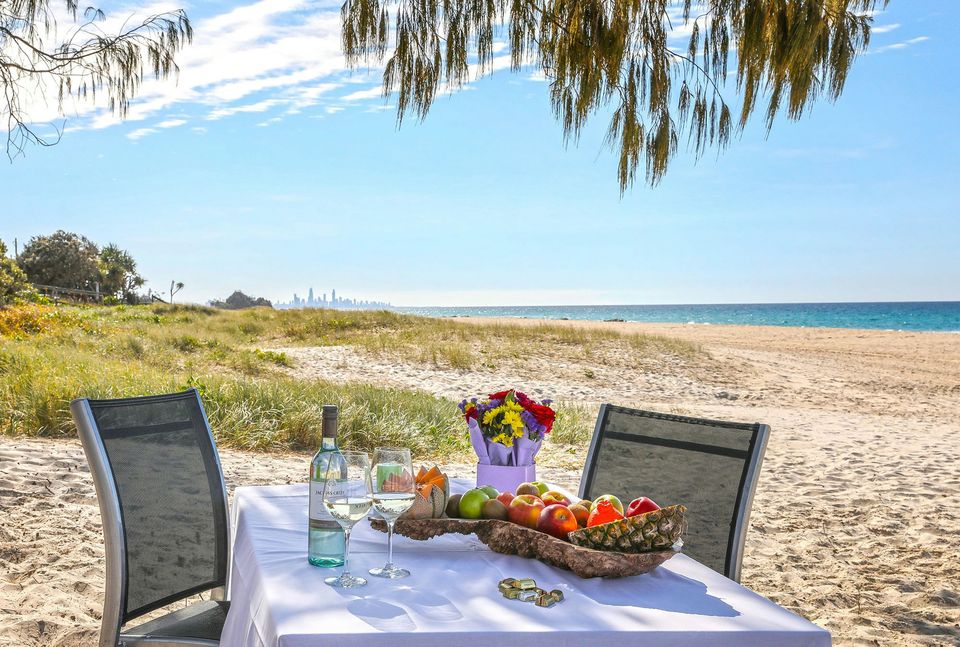 Picnic table set with fruit on the sand at Tugun Beach