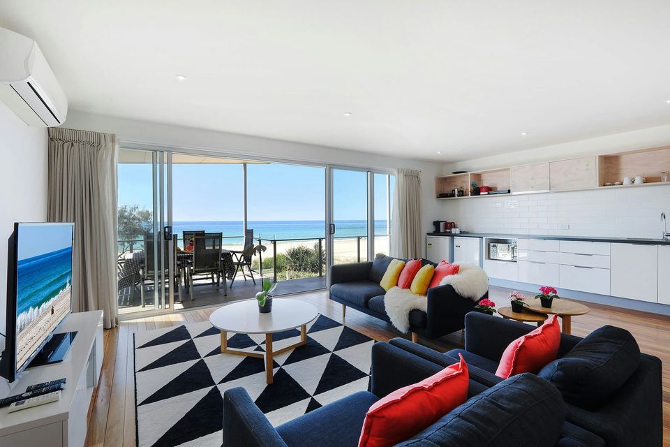 Living room with ocean views through the sliding doors at Sandbox Apartments